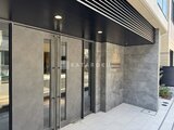 エスレジデンス亀戸バーム モダンな石貼りのエントランスと大型ガラス引き戸の外観