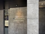 エスレジデンス亀戸バーム モダンな石貼りのエントランスと物件名表記の様子