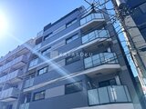 エスレジデンス亀戸バーム 青空の下、モダンなバルコニー付きの建物外観