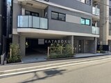 エスレジデンス亀戸バーム 街路から見た駐車場入口とモダンな建物ファサード