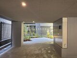 エスレジデンス亀戸バーム 明るい光が差し込むガレージスペースと庭園が見える共用エントラ