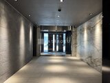 エスレジデンス亀戸バーム モダンな仕上げのエントランスホール、奥にガラス扉が見える