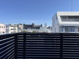 エスレジデンス亀戸バーム バルコニーの手すりごしに見る都市風景と青空