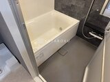 エスレジデンス亀戸バーム 白いバスタブと濃いグレーのアクセントパネルが落ち着いた浴室