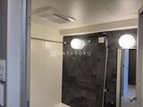 エスレジデンス亀戸バーム 黒いタイル貼りの浴室、明るい照明と換気乾燥機付き