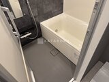 エスレジデンス亀戸バーム 白いバスタブと暗めのアクセントパネルを備えたバスルーム