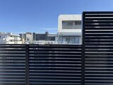 エスレジデンス亀戸バーム モダンな黒いルーバーフェンスから見た街並みと建物外観
