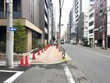 ブランシエスタ入谷グランデ 建ち並ぶビルに囲まれた街路樹のある歩道と車道の様子