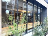 ブランシエスタ入谷グランデ 大きなガラス窓とグリーンを配置した開放的なエントランス外観