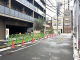 ブランシエスタ入谷グランデ 建設中の外観で、緑のフェンスと赤いコーンが設置された敷地の様