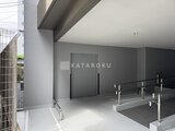 リテラス南千住サウス モダンな共用エントランスホール、グレー壁とステンレス手すりの