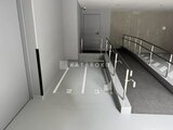 リテラス南千住サウス 駐車場の連続した駐車スペースと階段への動線が見える共用通路