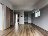 リテラス南千住サウス 木目調フローリングとグレー壁でまとめられた開放的なリビングダ