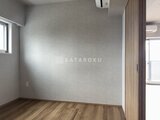 リテラス南千住サウス 木目調の建具と淡いグレーの壁が落ち着いた印象の洋室
