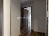 リテラス南千住サウス 落ち着いた色合いの廊下と濃い色の建具が調和した通路の様子