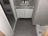 リテラス南千住サウス 白い洗面台と暗めの床材が落ち着いた印象の洗面脱衣室