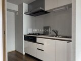 リテラス南千住サウス モダンな色合いのシステムキッチンと作業スペースが広がる空間