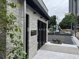 エスレジデンス千住大橋ブロード モダンな石貼りの外観とウッドデッキのエントランス
