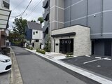 エスレジデンス千住大橋ブロード 石積み調のエントランスと駐車スペースを備えたモダンな建物外観