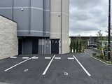 エスレジデンス千住大橋ブロード モダンな外観の建物と整備された駐車スペースの様子