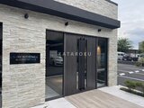 エスレジデンス千住大橋ブロード モダンな石積みの外壁を持つエントランスとガレージの様子