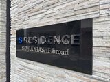 エスレジデンス千住大橋ブロード レンガ調の壁に設置された物件銘板とロゴ