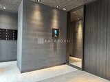 エスレジデンス千住大橋ブロード モダンなエレベーターホール、グレー基調の落ち着いた空間設計