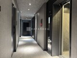 エスレジデンス千住大橋ブロード モダンな内装のエレベーターホール、複数の扉と落ち着いた照明が