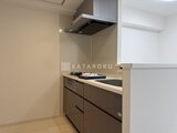 エスレジデンス千住大橋ブロード 落ち着いた色合いの対面キッチンと調理スペースの様子