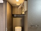 エスレジデンス千住大橋ブロード タンクレストイレと木目調の収納が備わるトイレ空間