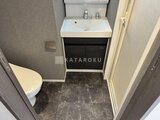 エスレジデンス千住大橋ブロード トイレと洗面台が一体となった、落ち着いた色合いの洗面化粧台