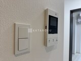 エスレジデンス千住大橋ブロード 玄関脇の壁に取り付けられた操作パネルと照明スイッチ