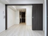 エスレジデンス千住大橋ブロード ダークフレームの引き戸で間仕切られた明るいリビングダイニング