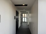 リビオメゾン田端 モダンな共有廊下、奥に採光窓がある落ち着いた空間