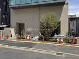 プレディアコート北千住 前面道路から見たモダンな建物外観と緑のある入口周辺