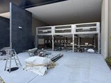 プレディアコート北千住 建設中のガレージエントランス、白いシャッターと工事資材が置か