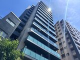 プレディアコート北千住 青空を背景とした建物外観、モダンな縦ラインデザインの高層マン