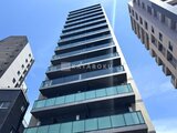 プレディアコート北千住 下から見上げた建物外観、モダンな縦ラインが印象的