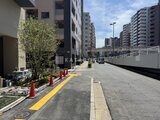 プレディアコート北千住 建物前の開放的なアプローチ、緑を配置した駐車場入口の様子