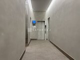 プレディアコート北千住 モダンな壁面と照明が特徴の廊下からエレベーターへ向かう通路