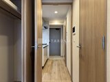 プレディアコート北千住 木目調でまとめた廊下から玄関とキッチンへの動線