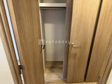 プレディアコート北千住 木目調のドア開口から見たゆとりのあるクローゼット空間