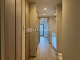 プレディアコート北千住 落ち着いた色調の廊下から玄関・リビング方向を見通す空間