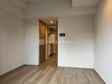 プレディアコート北千住 木調フローリングの床と白い壁面で明るく開放的な1Kの居室空間