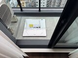 プレディアコート北千住 窓際に設置された浴室乾燥機と都市風景が見える開放的な空間
