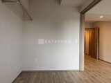 プレディアコート北千住 明るい照明で整った洋室から廊下方向を見た空間