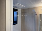 プレディアコート北千住 モダンなデザインの浴室、木目調パネルと浴室乾燥機備付けの様子