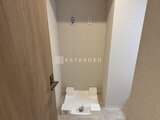 プレディアコート北千住 洗濯機置き場として整えられた、落ち着いた色合いの室内スペース