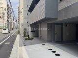 クラリティア上野稲荷町 モダンな外観の建物エントランスと駐車スペースの様子