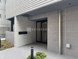 クラリティア上野稲荷町 モダンな石造りの建物エントランスと植栽が配された開放的な玄関